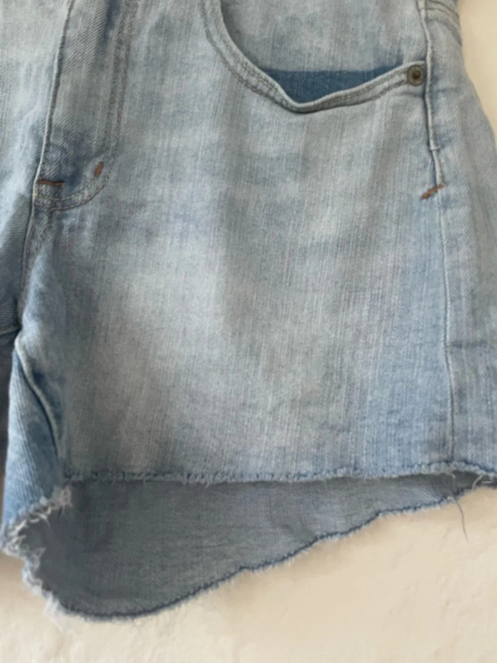 American Eagle women’s mid rise mid wash distressed hem cut off denim shorts; 10